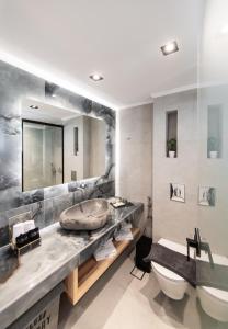 een badkamer met een wastafel en een grote spiegel bij Solvio Boutique Hotel & Spa in Lefkada