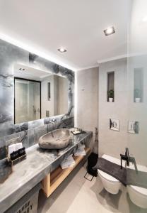 a bathroom with a sink and a large mirror at Solvio Boutique Hotel in Lefkada