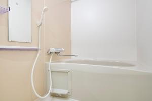 y baño blanco con ducha y lavamanos. en Livion III, en Tokio