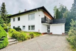 a white house with a driveway in front of it at Schöne Wohnung "Bethel" in Bad Hersfeld in Bad Hersfeld
