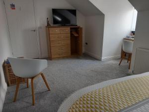 a bedroom with a bed and a television and a dresser at No. 5 in Hartlepool