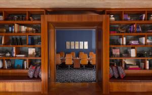 a room with wooden bookshelves with chairs and a mirror at Sheraton Baku Intourist in Baku