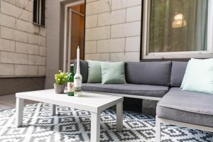 a couch and a table on a patio at Spacious Apartment, 3 min to U1 Reumannplatz in Vienna