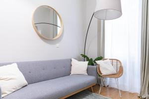 uma sala de estar com um sofá azul e um espelho em Spacious Apartment, 3 min to U1 Reumannplatz em Viena mais 38 fotografias