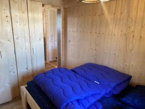 een groot blauw bed in een houten kamer bij lodge de Uitwijk in De Heen