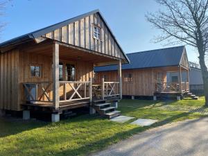 een groot houten huis met een gambrel dak bij lodge de Uitwijk in De Heen