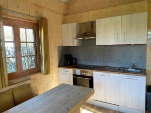 une cuisine avec des placards blancs et une table en bois dans l'établissement lodge de Uitwijk, à De Heen
