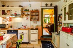 een keuken met witte kasten en een fornuis met oven bij Fairy Cottage in Rhauderfehn