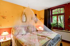 een slaapkamer met een bed met een klamboe bij Fairy Cottage in Rhauderfehn