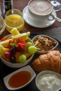 a tray of food with fruit and bread and a drink at Clos Malverne Wine Estate in Stellenbosch