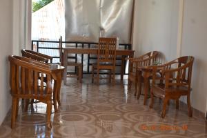 comedor con sillas de madera y mesa en JOHN'S HOMESTAY en Labuan Bajo