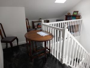 a stairway with a wooden table and a white railing at No. 5 in Hartlepool