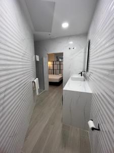 a white bathroom with a sink and a counter at APARTAMENTOS PLAYA VALENCIA in Valencia
