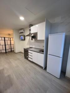 a kitchen with white cabinets and a white refrigerator at APARTAMENTOS PLAYA VALENCIA in Valencia
