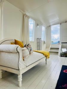 Un sofá blanco en una habitación con ventanas. en The Island Houseboat, en Ámsterdam