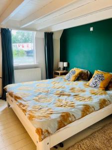 Una cama grande en un dormitorio con una pared verde. en The Island Houseboat, en Ámsterdam