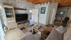 a living room with a couch and a tv at Ferienhaus Seekieker Timmel in Großefehn 