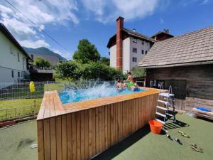 two people in a pool with a fountain at BikeSki family hotel, b&b, apartaments, rooms in Mežica