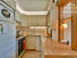 ル・グラン・ボルナンにあるAppartement Le Grand-Bornand, 4 pièces, 9 personnes - FR-1-391-23の白いキャビネット、シンク、冷蔵庫付きのキッチンが備わります。