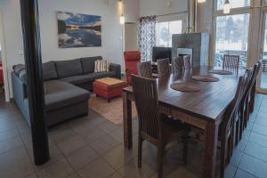 a living room with a wooden table and a couch at Hyvärilä Youth- and Holiday Centre in Nurmes