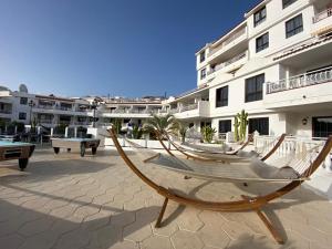 a hammock on a patio in front of a building at Apartamento Soña Club Tenerife Los Cristianos in Los Cristianos