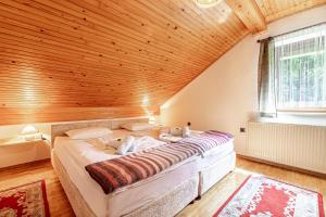 a large bed in a room with a wooden ceiling at House Mavko Near Lake Cerknica - Happy Rentals in Grahovo