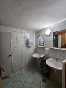 a bathroom with two sinks and a mirror at Ruška koča in Hočko Pohorje