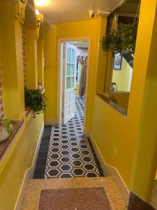 un pasillo con paredes amarillas y una puerta blanca en Our HomeStay, en Hai Phong