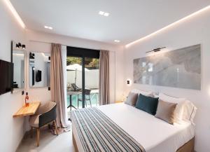 a bedroom with a bed and a desk and a table at Solvio Boutique Hotel & Spa in Lefkada