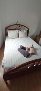 a bed with two towels and a pair of shoes on it at Casa Avô T1 in Avô