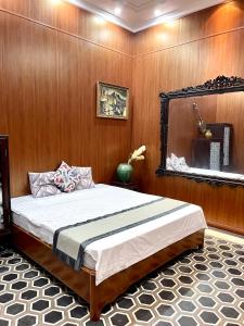 1 dormitorio con 1 cama grande y espejo en Our HomeStay, en Hai Phong