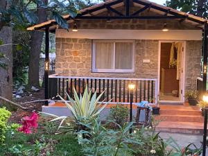 a stone house with a pergola on the front porch at Yelagiri Villa in Yelagiri