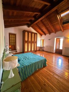 1 dormitorio con 1 cama en una habitación con suelo de madera en Relax tra Monferrato & Langhe en SantʼAndrea