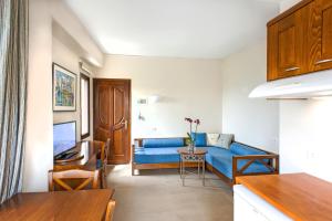 Una sala de estar con un sofá azul y una mesa. en Frideriki Studios & Apartments, en Plataniás