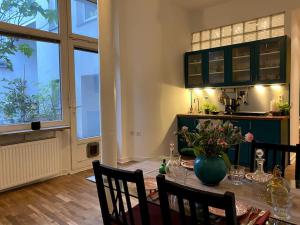 Un comedor con una mesa con un jarrón de flores. en Cosy & central flat near Düsseldorf center, en Düsseldorf 6 fotos más