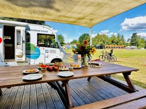 a picnic table on a deck with a food truck at Julinek CAMP in Leszno