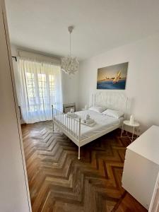 a bedroom with a white bed and wooden floors at Casa Vittorio in Turin