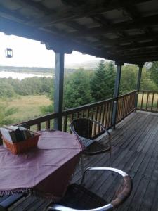 a table and chairs on a deck with a view at Traditional Wooden Apartment in Koutsodímos