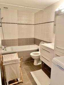 e bagno con servizi igienici, vasca e lavandino. di Appartement au coeur de Nice pour 4 - Clim & Wifi a Nizza