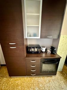 a kitchen with a cupboard and a microwave at Casa Vittorio in Turin