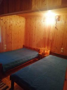 two beds in a room with wood paneling at Traditional Wooden Apartment in Koutsodímos