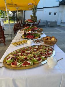 a table with many plates of food on it at Apartmani Albatros in Perušić
