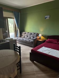 1 dormitorio con cama, sofá y mesa en Adrian Agustin Rooms, en Lukovë