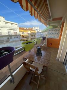 uma varanda com uma mesa de madeira e alguns lavatórios em Le St Pierre, joli T1 central à 2 minutes des plages em Menton