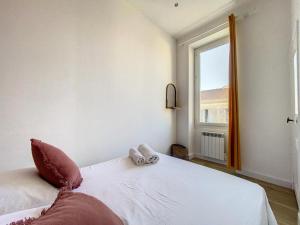 een slaapkamer met een groot wit bed en een raam bij Ultra Central - Le Quartier des Artistes - Les Frères de la Loc' in Marseille