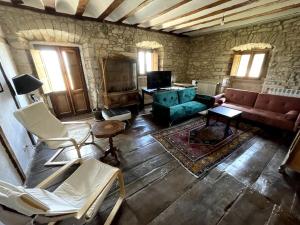 a living room with a green couch and chairs at Caserío `The Formicary´ in Antezana de la Ribera