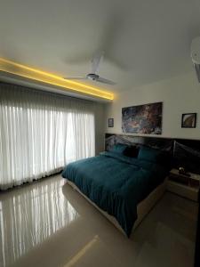 a bedroom with a green bed and a ceiling fan at Eiffel Tower Apartment in Rawalpindi