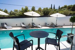 a patio with a table and chairs next to a swimming pool at Solvio Boutique Hotel in Lefkada