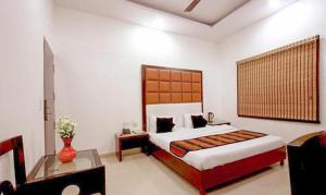 a bedroom with a bed and a vase of flowers at FabHotel Station 3 in New Delhi