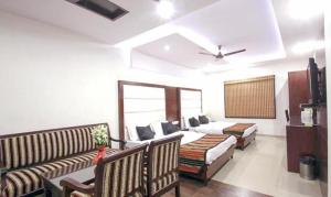 a living room with two beds and a couch at FabHotel Station 3 in New Delhi